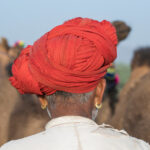 Man wearing a traditional red turban at the Pushkar Camel Fair in Rajasthan, India Title