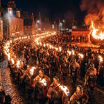 Participants carrying flaming torches during the Up Helly Aa festival in Scotland as a Viking longship burns in the background.