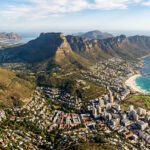 Aerial view of Cape Town with Table Mountain, the Atlantic coastline, and surrounding neighborhoods in South Africa.