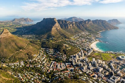 Aerial view of Cape Town with Table Mountain, the Atlantic coastline, and surrounding neighborhoods in South Africa.